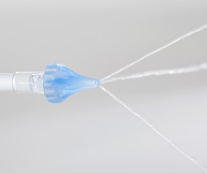 OtoClear tip spraying water for ear irrigation.